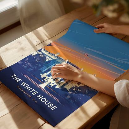 A person unrolls a vibrant poster of the White House with a sunset background on a wooden table. The text reads The White House, Washington D.C.