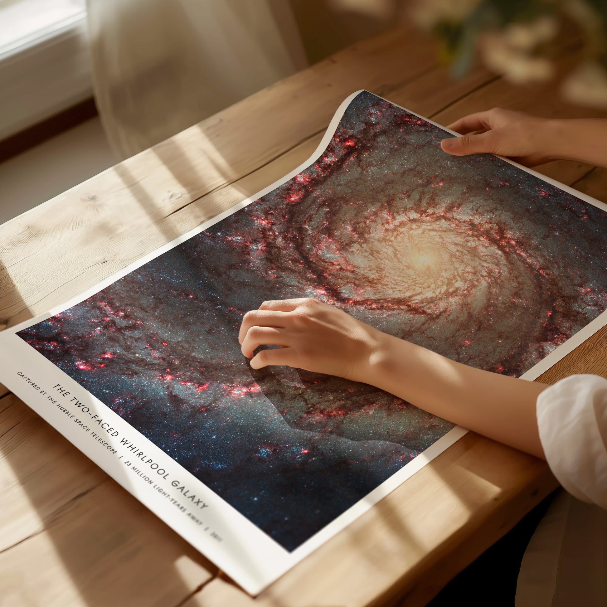 Unframed Whirlpool Galaxy M51 Hubble NASA poster printed on matte archival paper laid flat on a tabletop