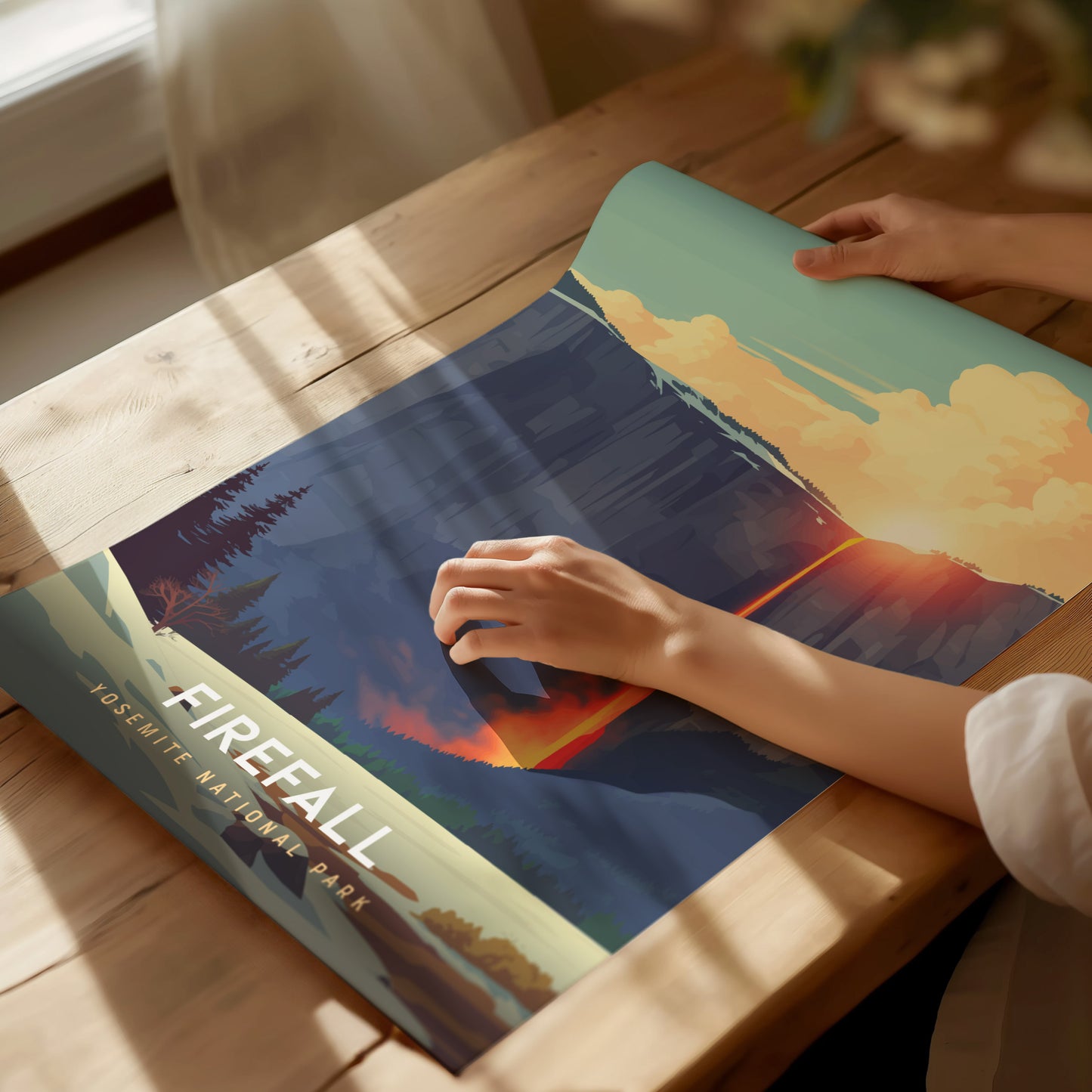 Person holding a book titled 'Firefall' with a scenic cover on a wooden table.