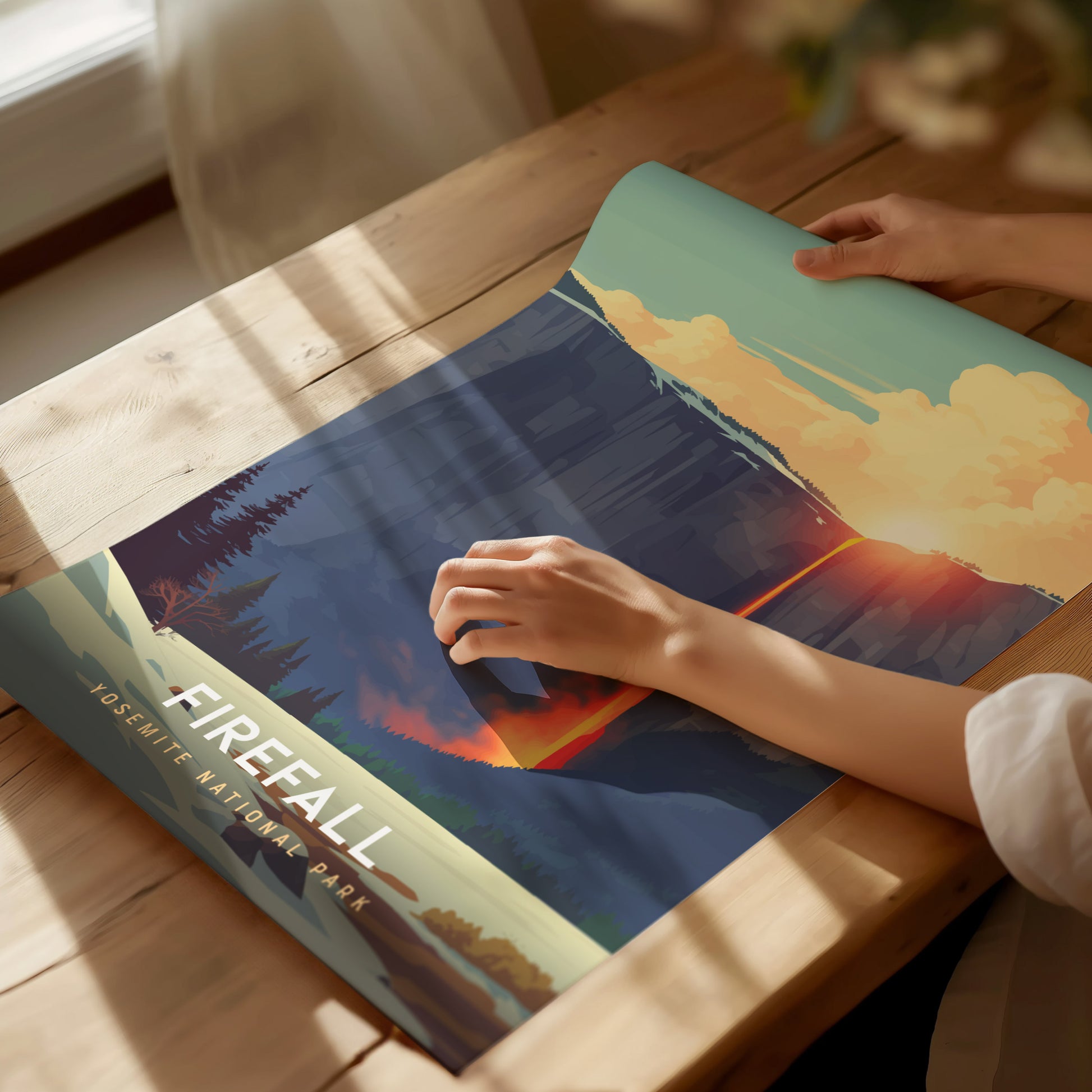 Person holding a book titled 'Firefall' with a scenic cover on a wooden table.