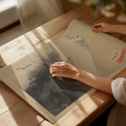 A person gently touches a Japanese ukiyo-e art print featuring a dragon and Mount Fuji, placed on a sunlit wooden table. Soft shadows enhance the serene ambiance.
