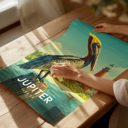 Person holding a poster of a pelican with Jupiter, Florida text on a wooden table.