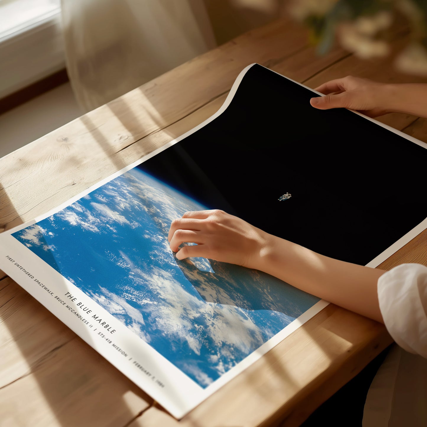 Unframed Blue Marble NASA spacewalk poster printed on matte archival paper laid flat on a tabletop