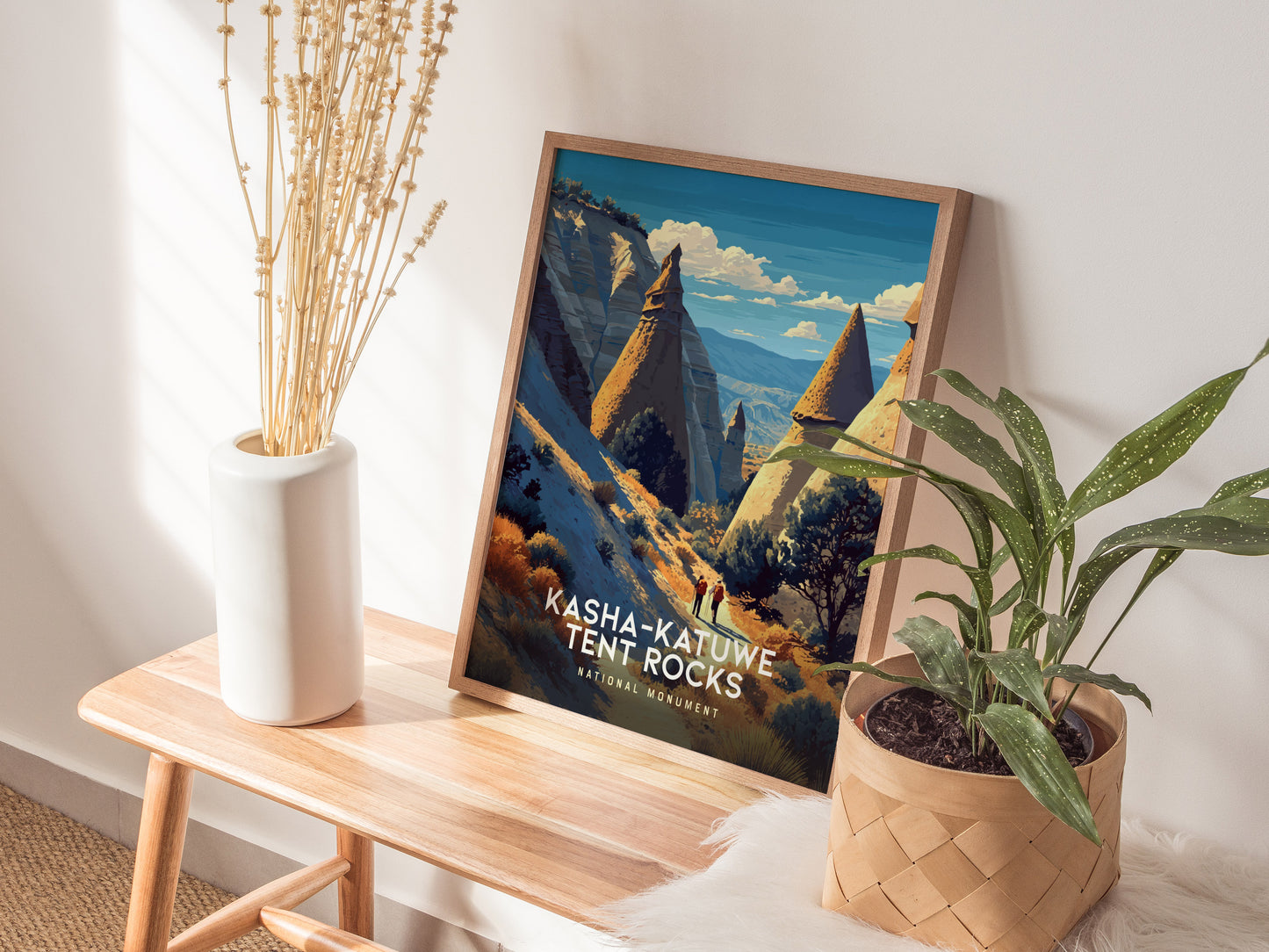 Framed vintage poster showcasing Kasha-Katuwe Tent Rocks' cone formations with hikers, featuring earthy tones and a vibrant blue sky.