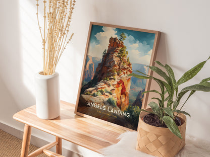 A framed Angels Landing poster rests on a wooden bench beside a white vase with dried stems and a potted plant. Sunlight casts soft shadows on the wall.