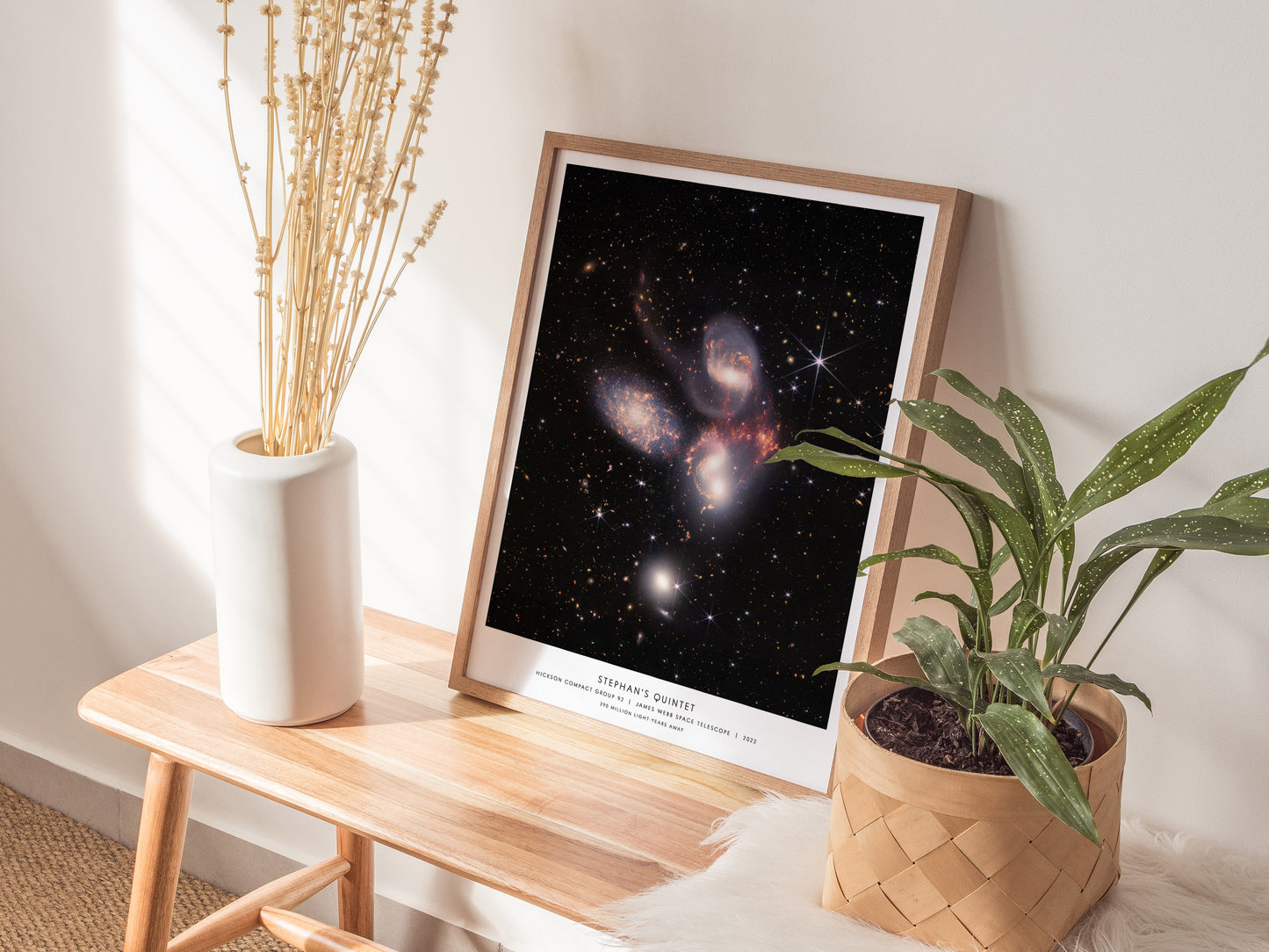 Framed Stephan's Quintet JWST wall art hanging on a white wall in a modern living room