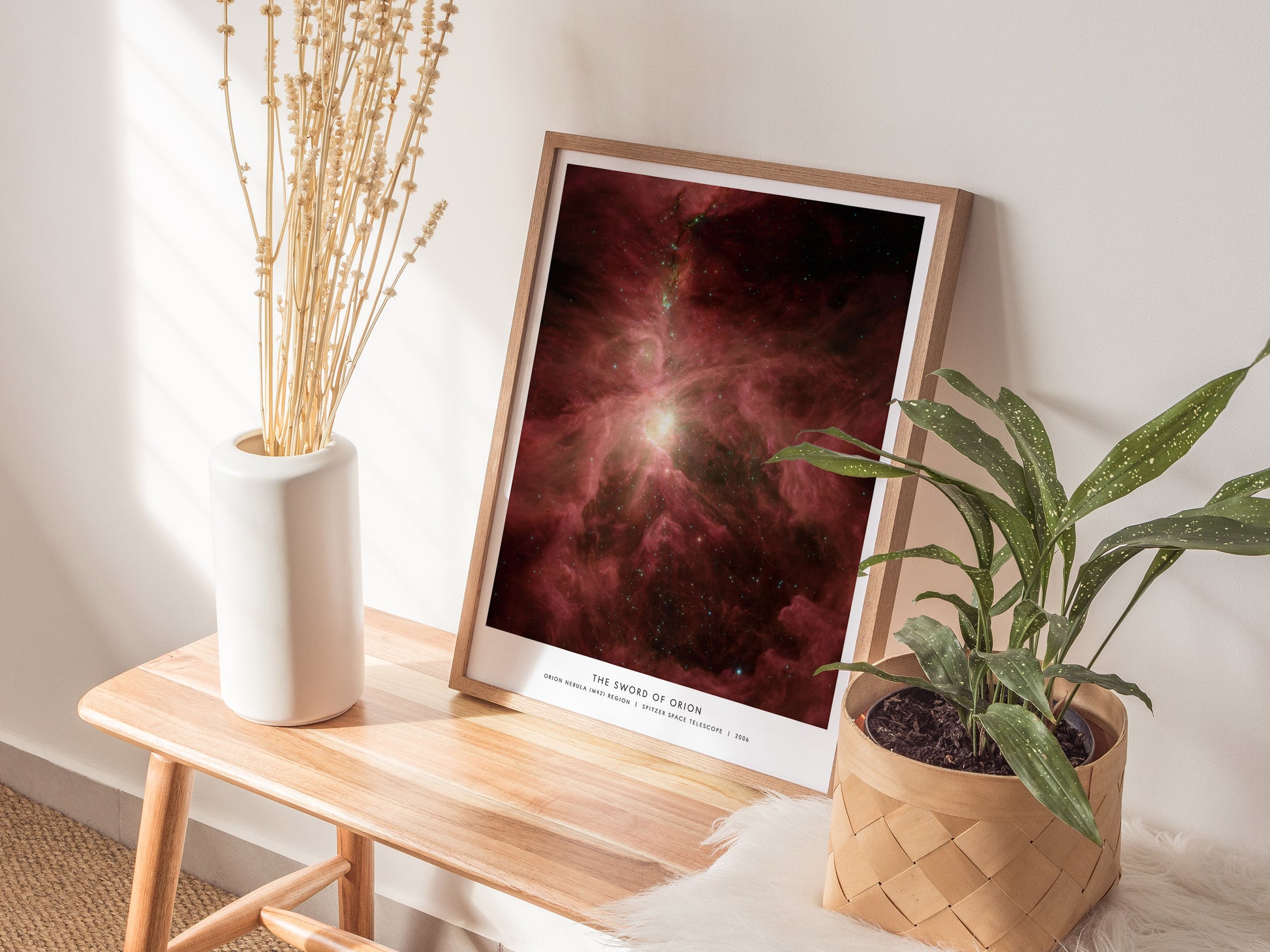 Natural wood framed Sword of Orion Orion Nebula print leaning on a shelf next to plants and neutral accessories