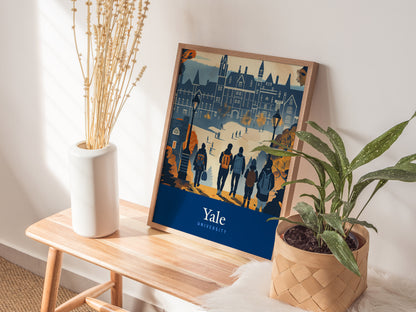 A framed poster of Yale University featuring Gothic architecture rests on a wooden bench beside a white vase with dried flowers and a potted green plant.
