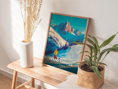 A framed Grand Targhee Resort poster featuring snowy mountains and a snowboarder is displayed on a wooden bench beside a white vase with dried plants and a potted green plant.