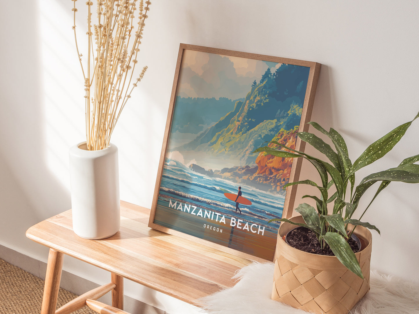 A framed poster of Manzanita Beach, Oregon, featuring a vibrant illustration of waves crashing against the shore with a surfer in the foreground. The scene is set against lush green hills and a clear blue sky, enhancing the coastal beauty.