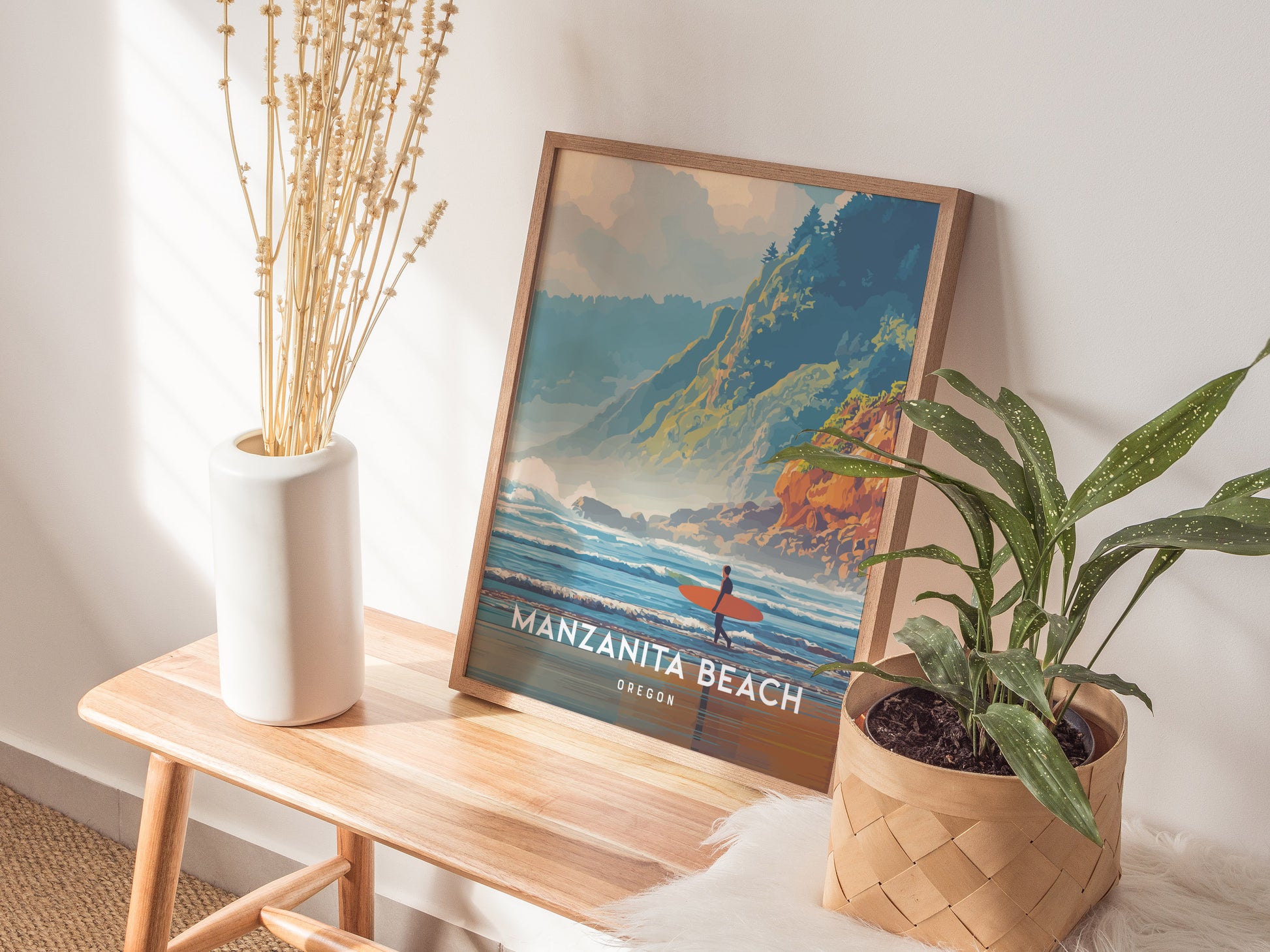 A framed poster of Manzanita Beach, Oregon, featuring a vibrant illustration of waves crashing against the shore with a surfer in the foreground. The scene is set against lush green hills and a clear blue sky, enhancing the coastal beauty.