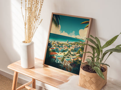 A framed Cancun poster with a vibrant tropical scene rests on a wooden table, accompanied by a white vase with dried flowers and a leafy green plant in a woven.