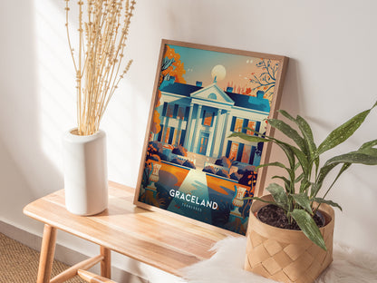 A framed poster of Graceland, Tennessee, is displayed on a wooden bench beside a white vase with long, dried plants and a green potted plant.
