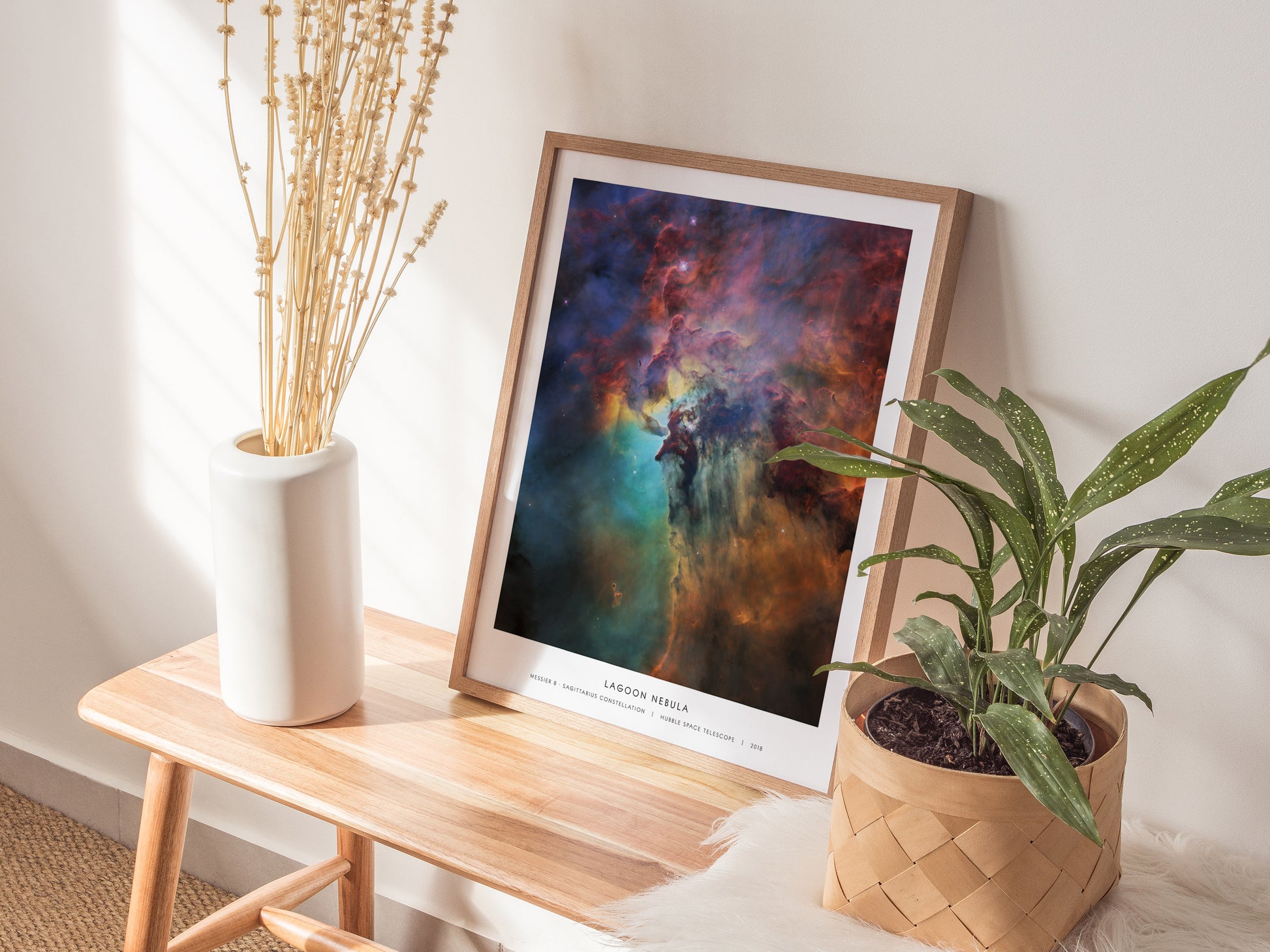 Framed Lagoon Nebula wall art in vibrant blues, purples, and reds, showcasing Sagittarius constellation space print by Swell Scenes.