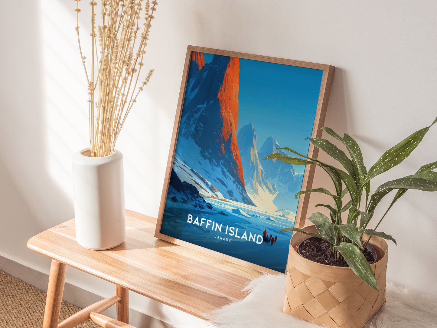 Framed Baffin Island wall art showcasing a sunrise over majestic mountains, with adventurers in winter gear traversing snowy terrain.