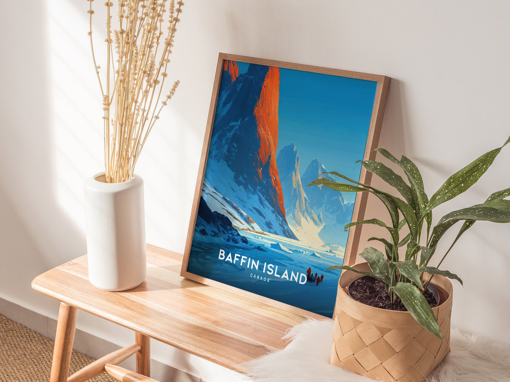 Framed Baffin Island wall art showcasing a sunrise over majestic mountains, with adventurers in winter gear traversing snowy terrain.