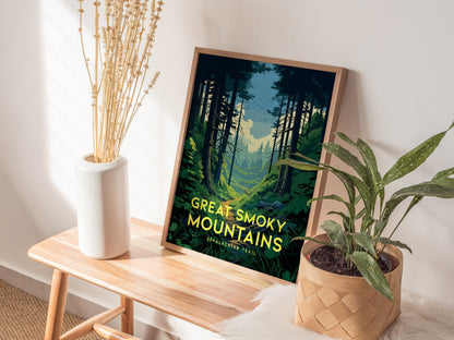 A framed Great Smoky Mountains poster rests on a wooden bench, accompanied by a white vase with dried flowers and a potted plant, creating a serene display.