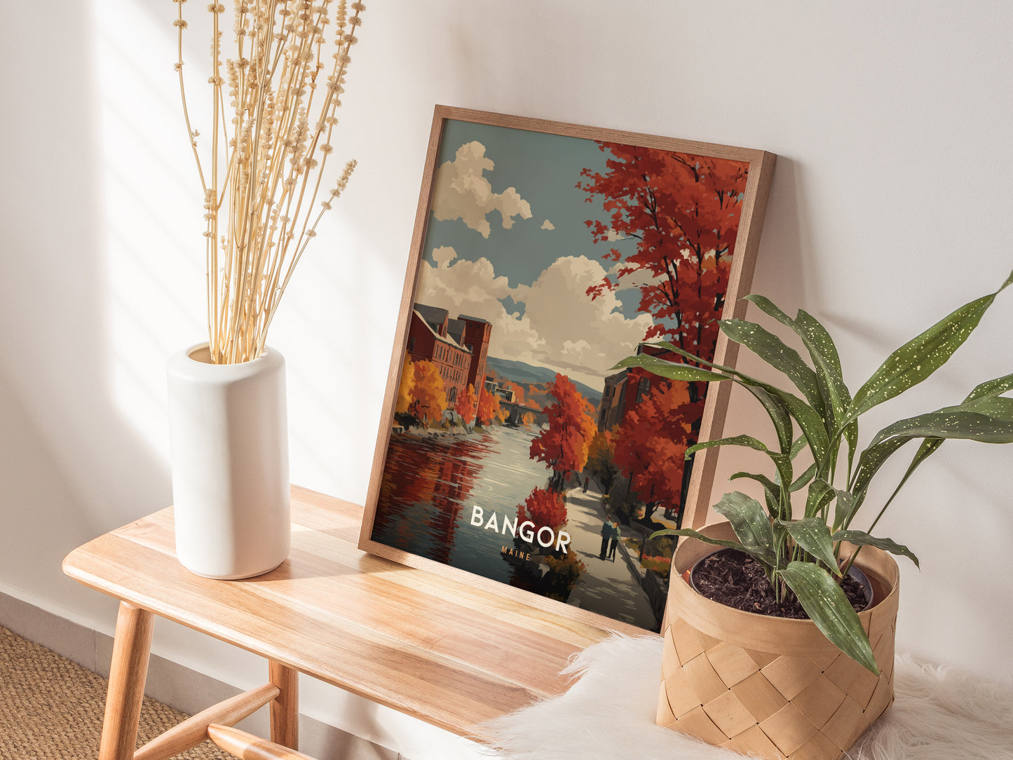 Framed Bangor, Maine autumn river scene travel print showcasing vibrant fall foliage, serene water, and vintage illustration style.