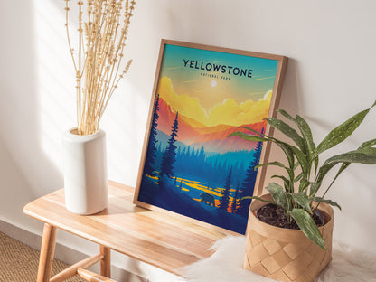 A framed Yellowstone National Park poster with a vibrant sunset and forest scene is displayed on a wooden bench, alongside a white vase with dried stems and a potted plant.