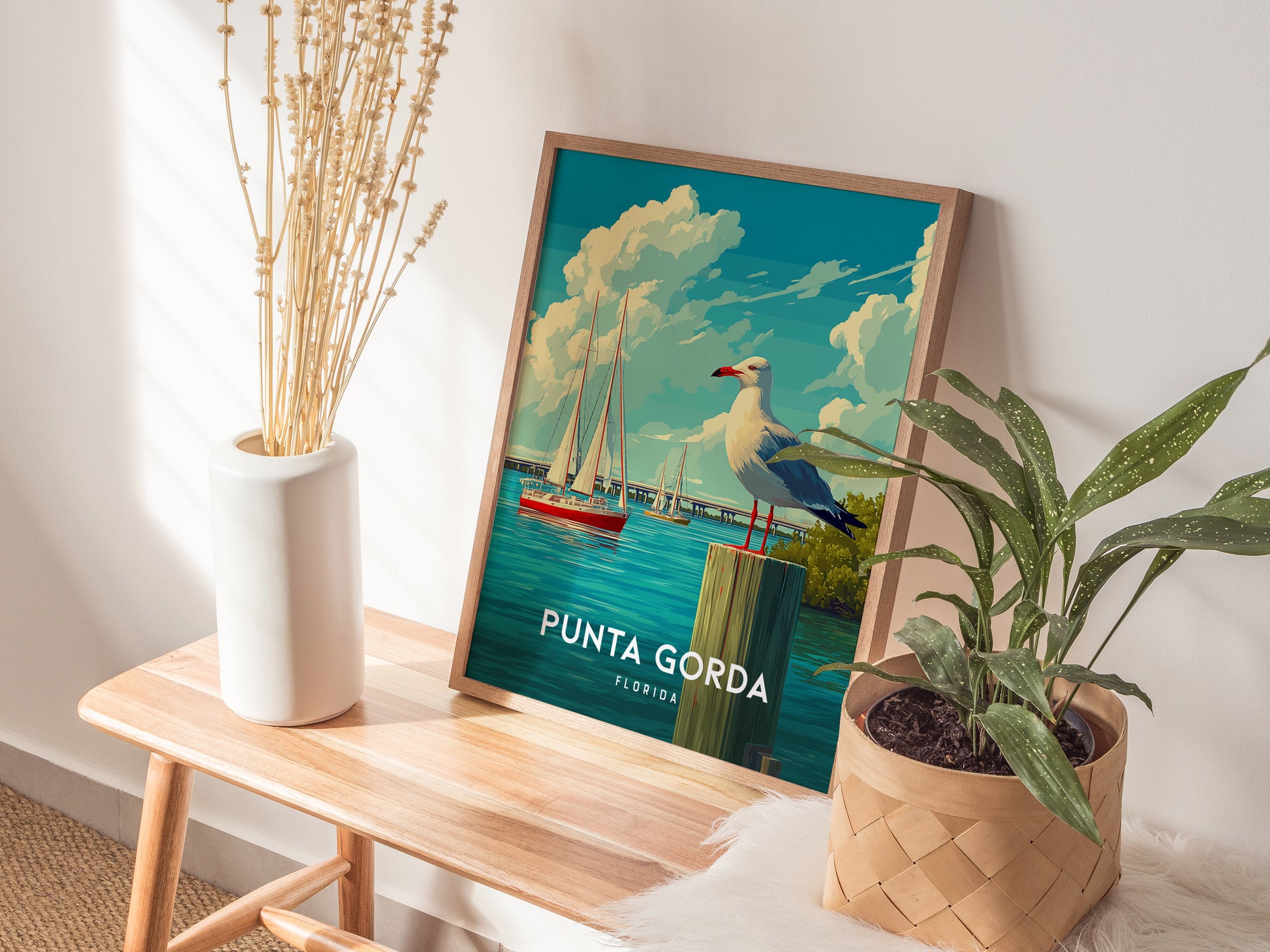 Framed Punta Gorda coastal poster featuring a seagull on a post, vibrant sailboats, and lush trees, perfect travel art.