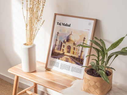 A framed Taj Mahal poster rests on a wooden bench, flanked by a white vase with dried flowers and a potted green plant. Natural light enhances the serene setting.