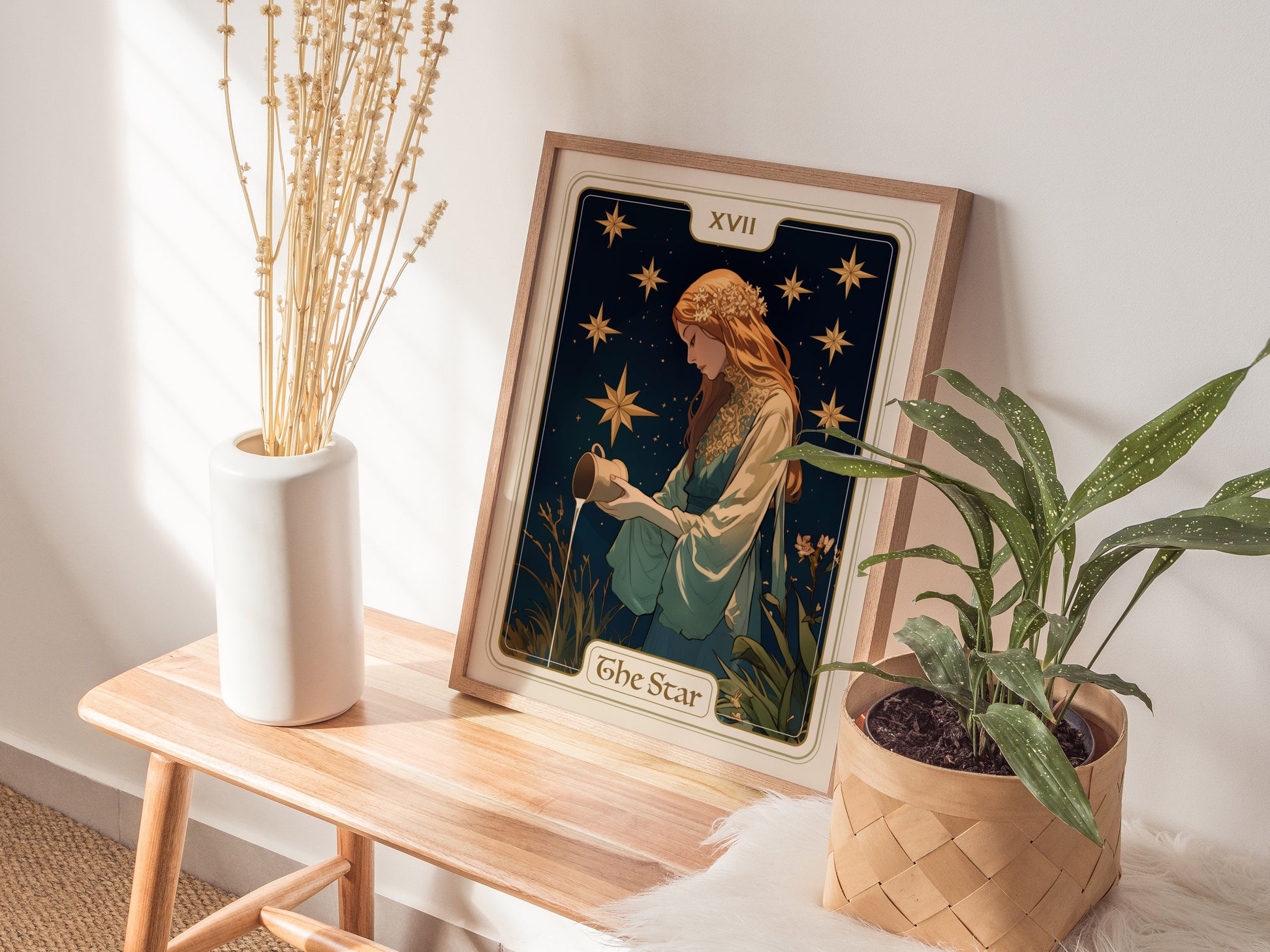 A framed Star Tarot Card XVII poster featuring a serene maiden is displayed on a wooden bench beside a white vase with dried flowers and a potted plant.