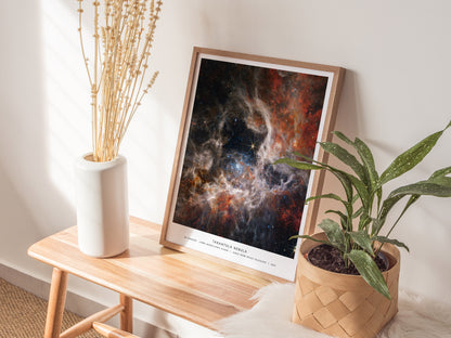 Natural wood framed Tarantula Nebula space print leaning on a shelf next to plants and neutral accessories
