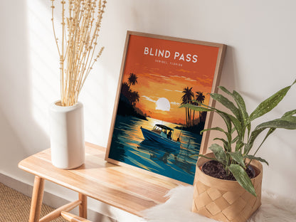 A framed poster titled Blind Pass, Sanibel Florida sits on a wooden bench, depicting a fisherman in a boat at sunset. Its surrounded by a vase and a potted plant.