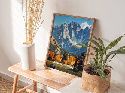 A framed Mount Whitney poster rests on a wooden bench, accompanied by a white vase with dried flowers and a potted green plant, creating a cozy, natural decor setting.