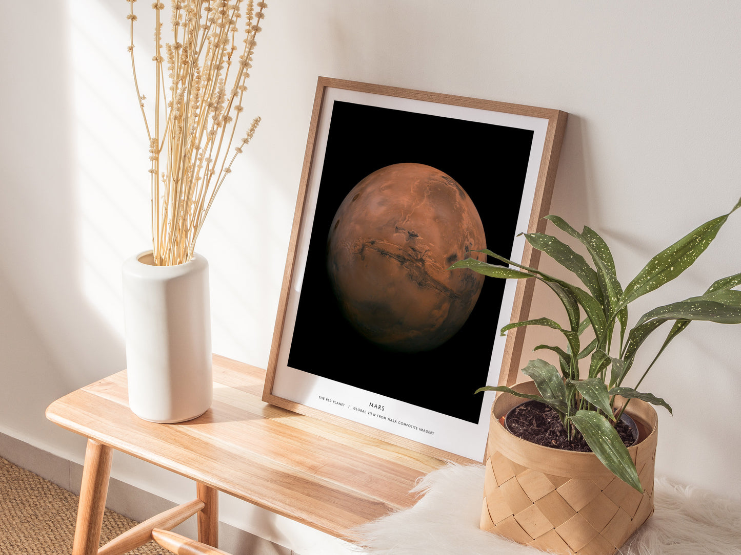 Framed poster of Mars on a wooden side table with plants and decor.
