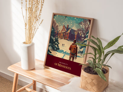 A framed University of Minnesota poster depicting a snow-covered campus scene with students walking is placed on a wooden bench, flanked by a vase of dried plants and a leafy.