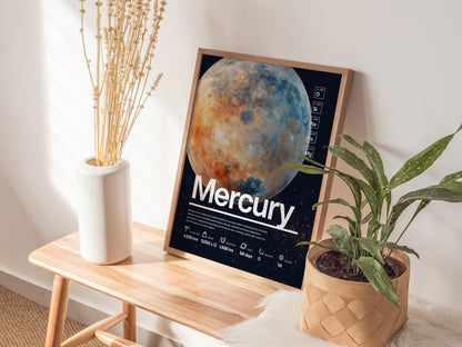 A framed Mercury poster rests on a wooden bench, surrounded by a white vase with dried flowers and a green potted plant, against a softly lit wall.
