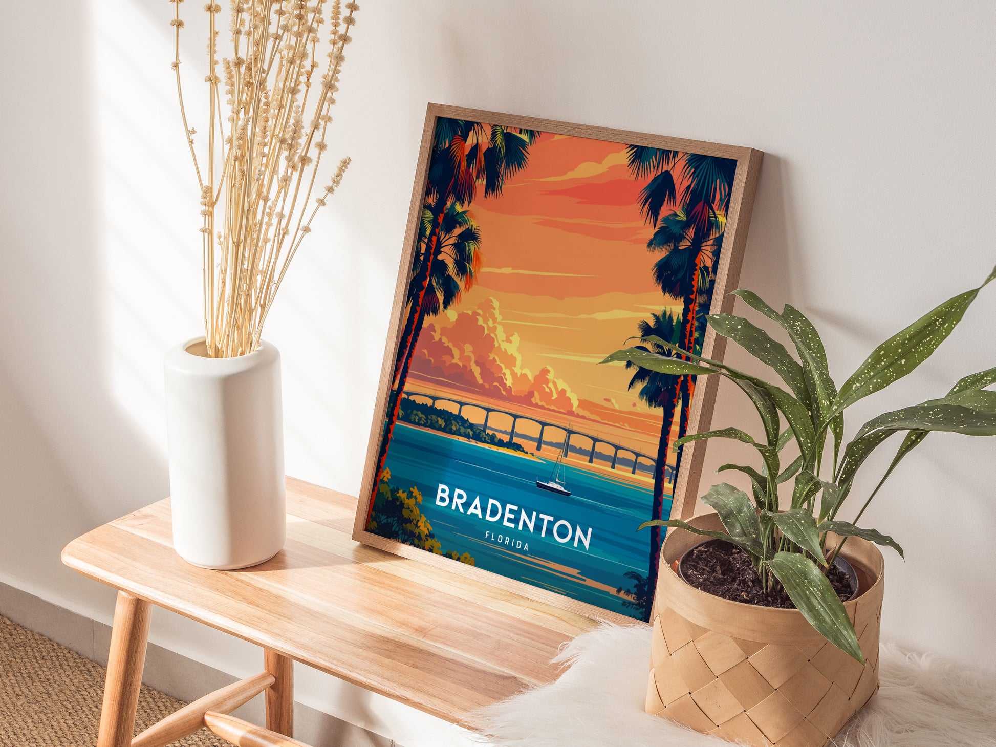 Framed Bradenton, Florida poster on a wooden table with plants and a vase.