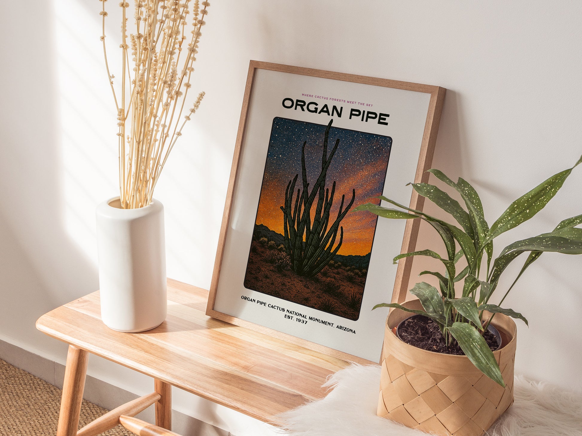 Framed print of 'Organ Pipe' with plants and a vase on a wooden table.