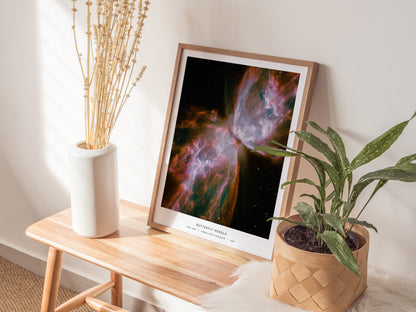 Framed Butterfly Nebula poster showcasing vibrant pink, purple, and green hues from Hubble Space Telescope photography, perfect for space art decor.