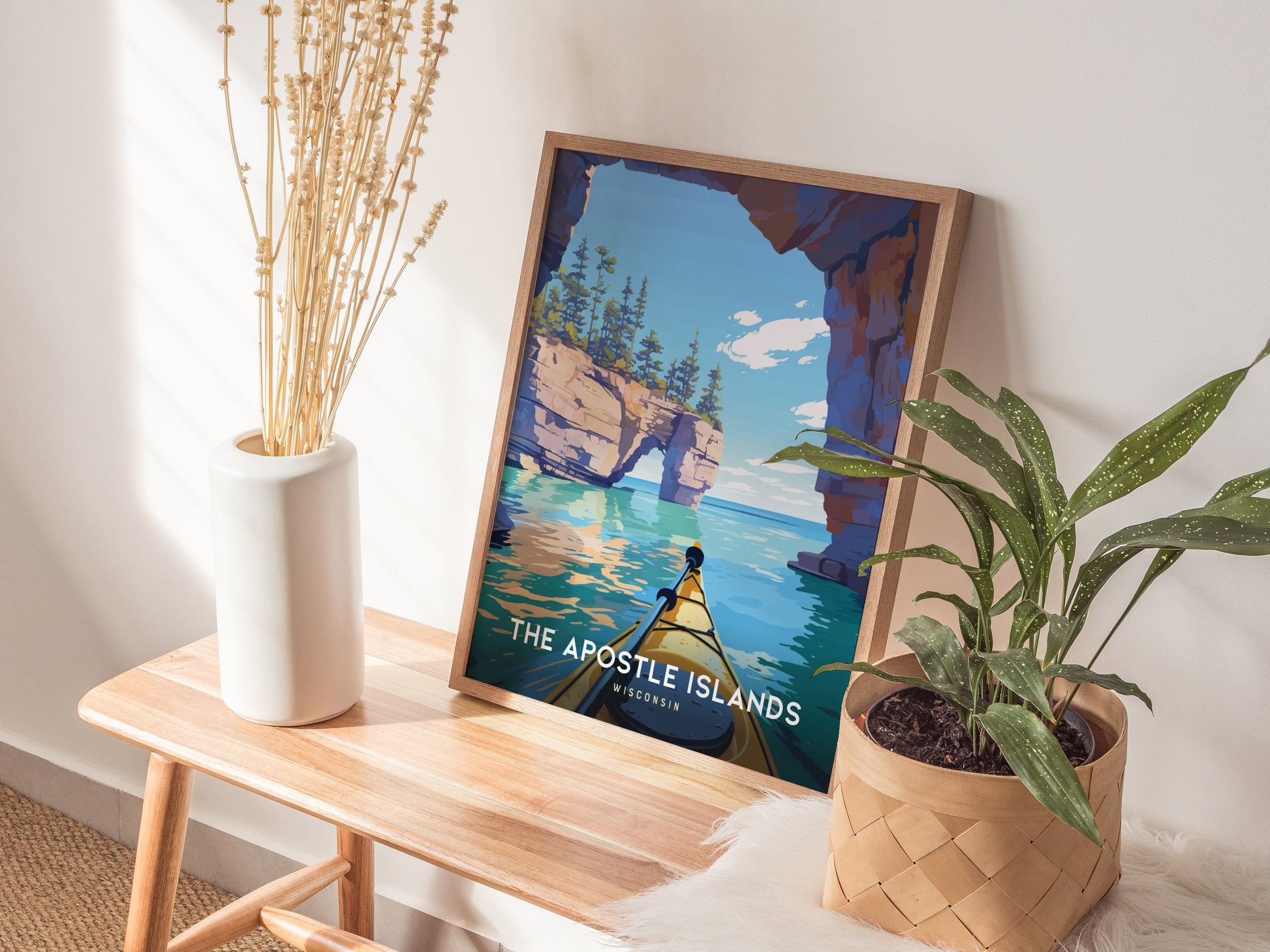 Framed Apostle Islands poster featuring a vibrant kayak scene with turquoise waters, rocky cliffs, and a clear sky, perfect for travel art lovers.