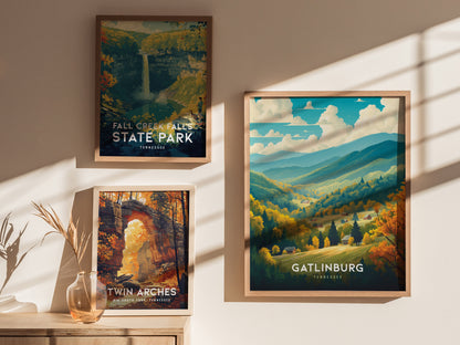 Three framed posters on a wall depict scenic landscapes: Fall Creek Falls State Park, Twin Arches, and Gatlinburg, featuring vibrant autumn colors and mountainous views under sunlight.