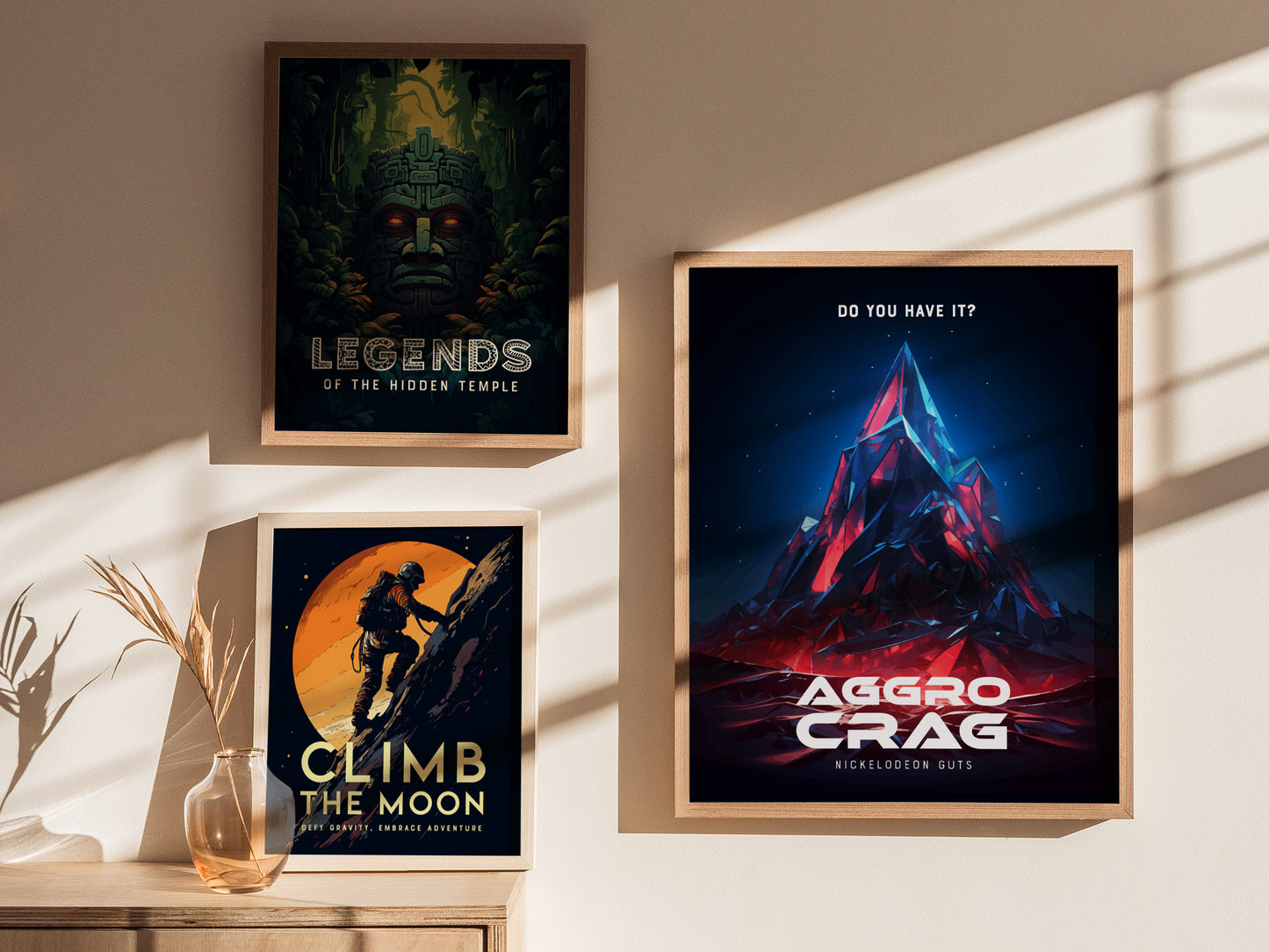 Three framed posters on a wall include Legends of the Hidden Temple, Climb the Moon, and Aggro Crag from Nickelodeon GUTS, all highlighted by natural light and shadows.
