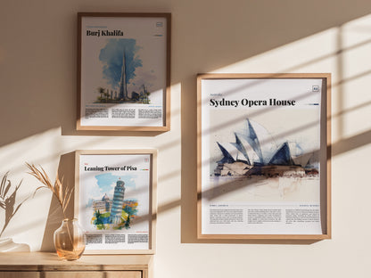 Framed posters of the Sydney Opera House, Burj Khalifa, and Leaning Tower of Pisa hang on a sunlit wall above a wooden surface with a vase.