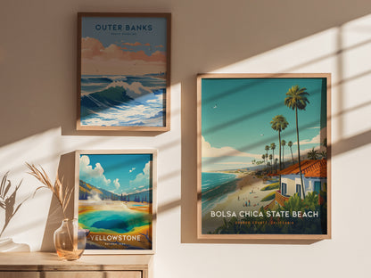 Three framed posters are displayed on a sunlit wall, featuring vibrant artwork of Outer Banks, Yellowstone, and Bolsa Chica State Beach, each showcasing coastal and natural landscapes.