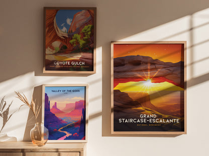 Three framed posters are displayed on a wall, featuring vibrant landscapes of Coyote Gulch, Valley of the Gods, and Grand Staircase–Escalante, with sunlight streaming through nearby windows.
