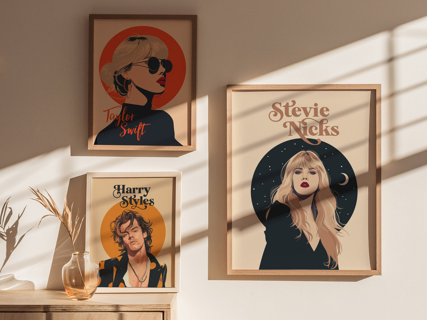 Three framed posters are displayed on a sunlit wall, featuring minimalist portraits of Taylor Swift, Stevie Nicks, and Harry Styles, with decorative celestial and circular backgrounds.