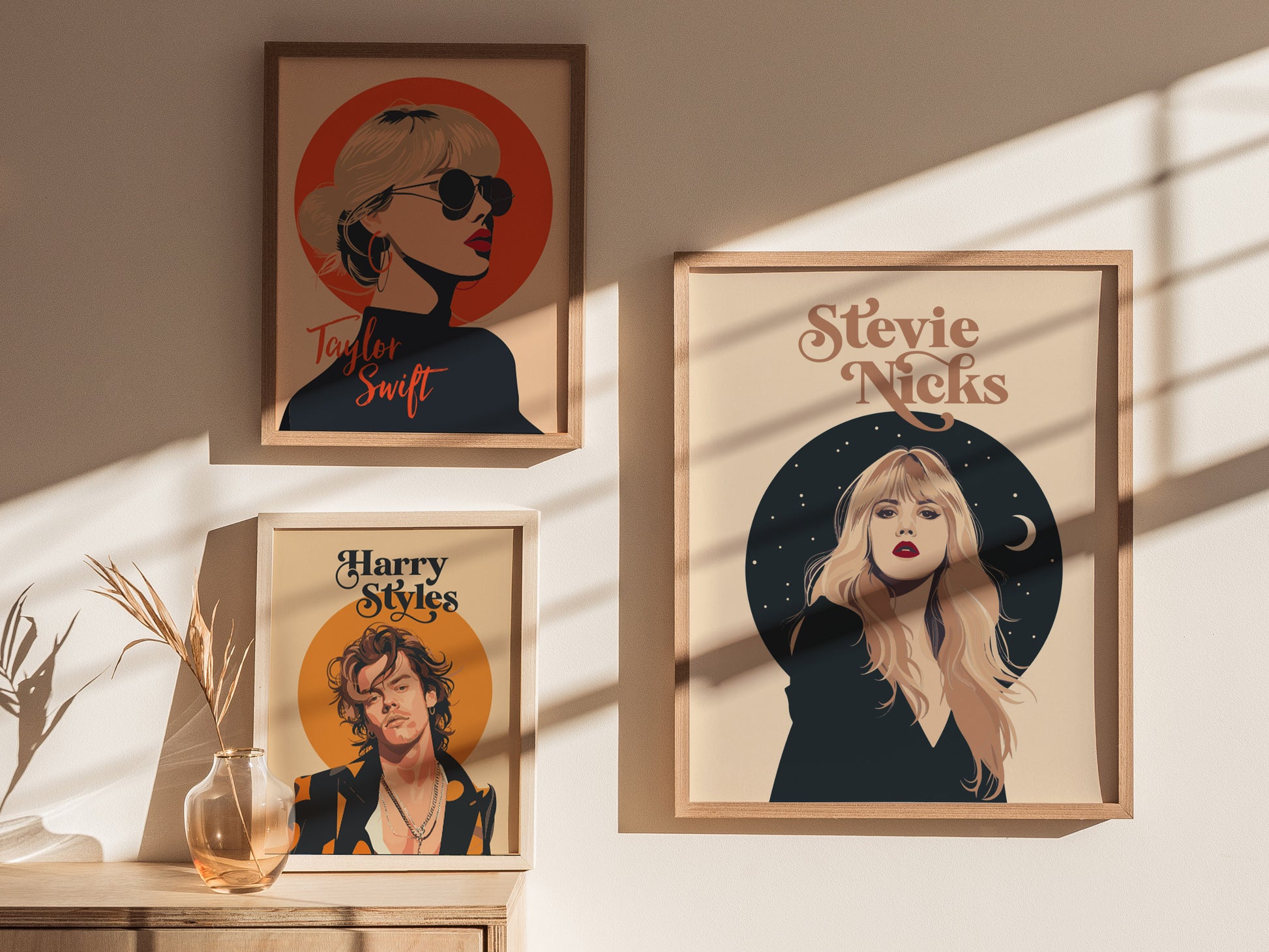 Three framed posters are displayed on a sunlit wall, featuring minimalist portraits of Taylor Swift, Stevie Nicks, and Harry Styles, with decorative celestial and circular backgrounds.