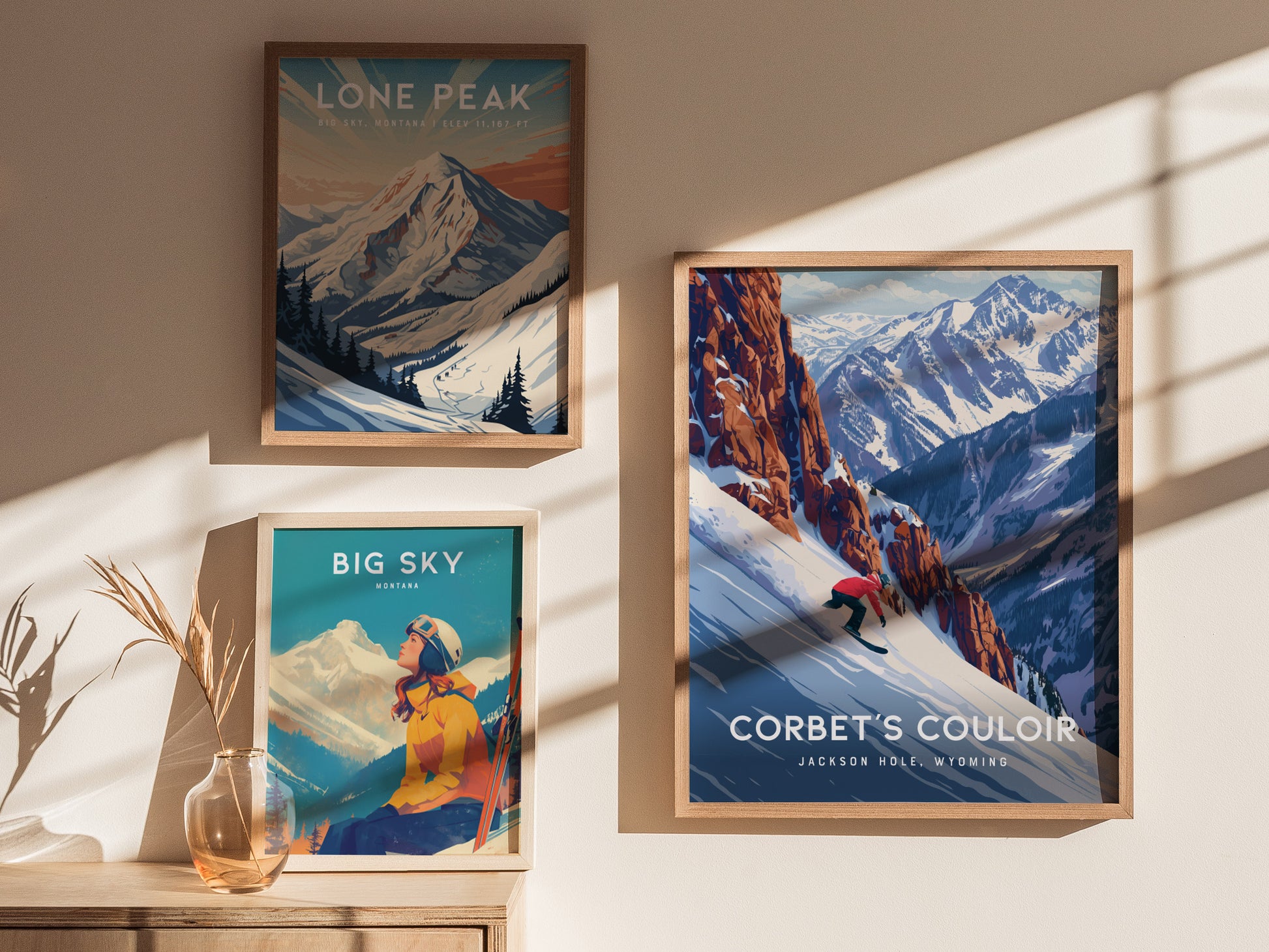 Framed posters on a wall depict mountain scenes: a snowboarder on Corbet’s Couloir, Jackson Hole; a scenic view of Lone Peak; and a skier in Big Sky, Montana.