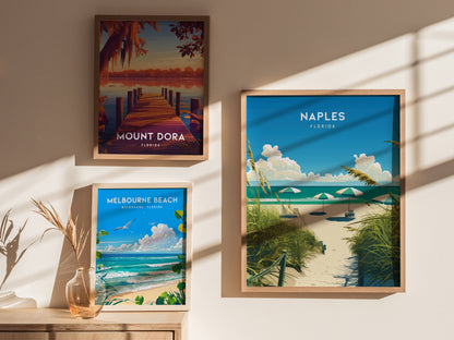 Three framed posters on a sunlit wall depict Mount Dora, Melbourne Beach, and Naples, Florida, showcasing scenic landscapes with water, foliage, and vibrant skies.