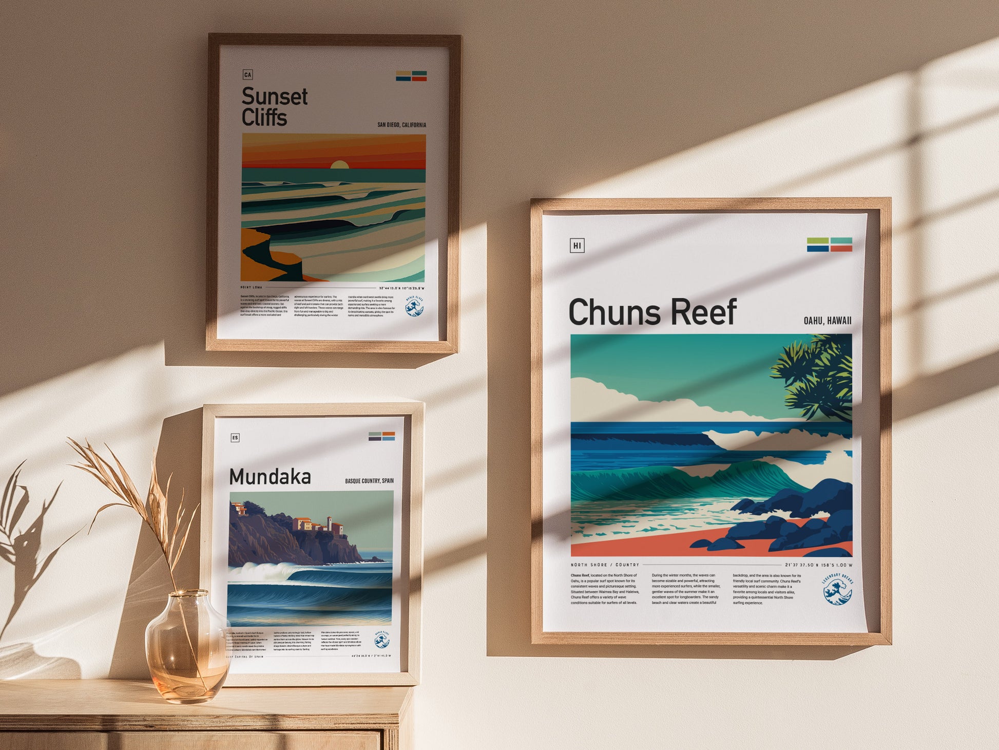 A stylish interior display featuring three framed surf spot posters on a wall, including the Chuns Reef poster prominently in the center.