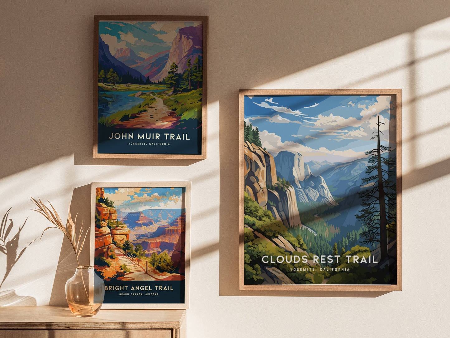Framed posters on a wall display scenic trails: John Muir Trail, Bright Angel Trail, and Clouds Rest Trail, each showcasing vibrant landscapes with mountains, valleys, and dramatic skies.