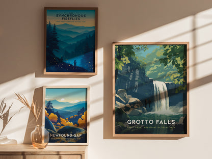 Three framed posters are displayed on a wall, each depicting scenes from the Great Smoky Mountains National Park. The Grotto Falls poster features a waterfall, while others showcase landscapes with mountains and fireflies.