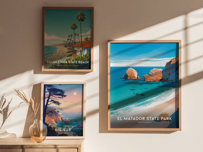 Framed posters of Bolsa Chica State Beach, Big Sur, and El Matador State Park are displayed on a wall, with sunlight casting shadows and a vase with dried plants on.