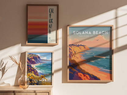 Three framed posters displayed on a wall feature vibrant coastal scenes, including Solana Beach and Del Mar, with warm tones and ocean views. Shadows and a decorative vase add depth.